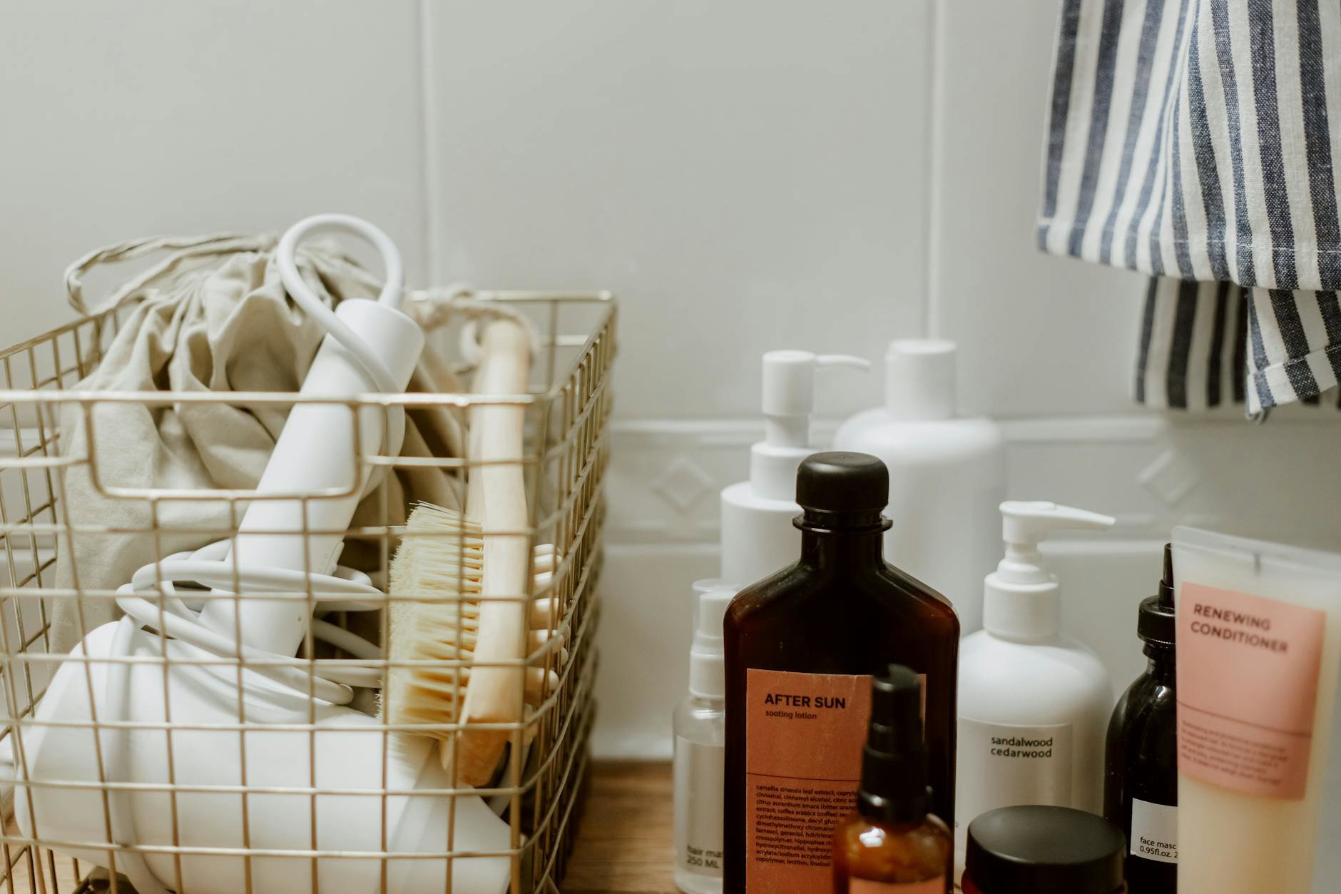 woman organising skincare products on bathroom shelf