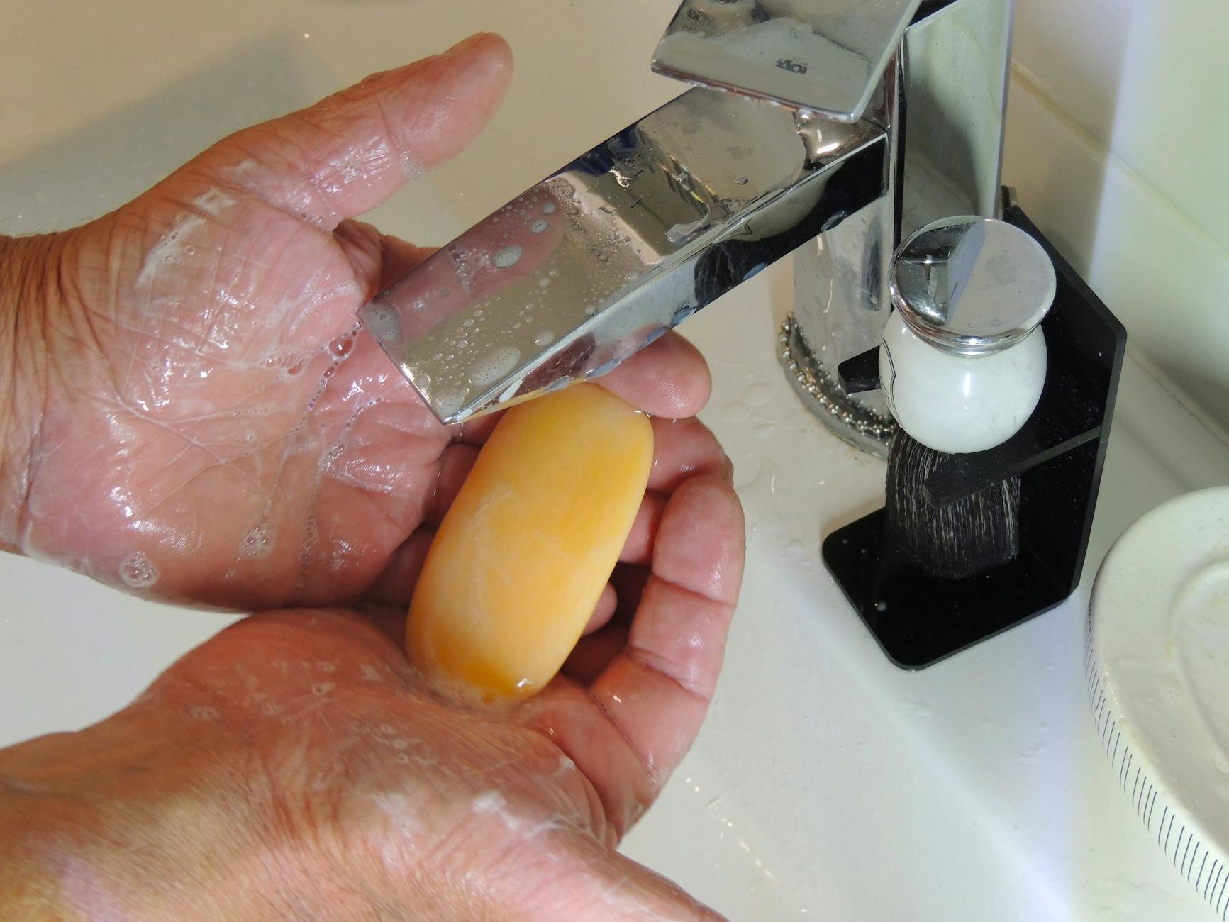 foaming face cleanser lather hands bathroom sink