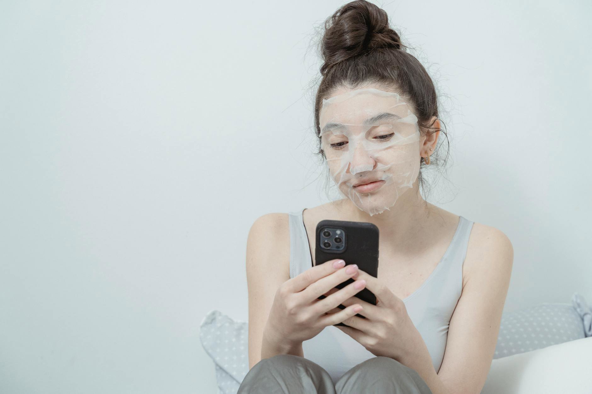 woman using LED face mask at home