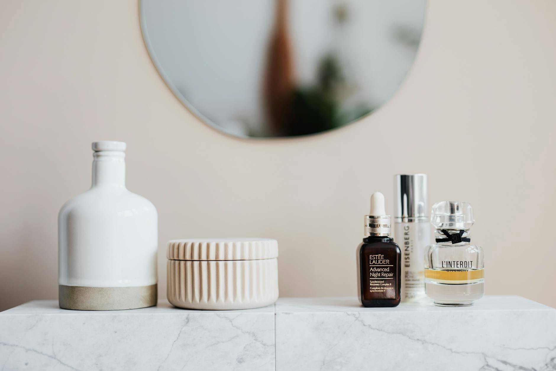 perfume bottle and skincare jar on vanity soft light