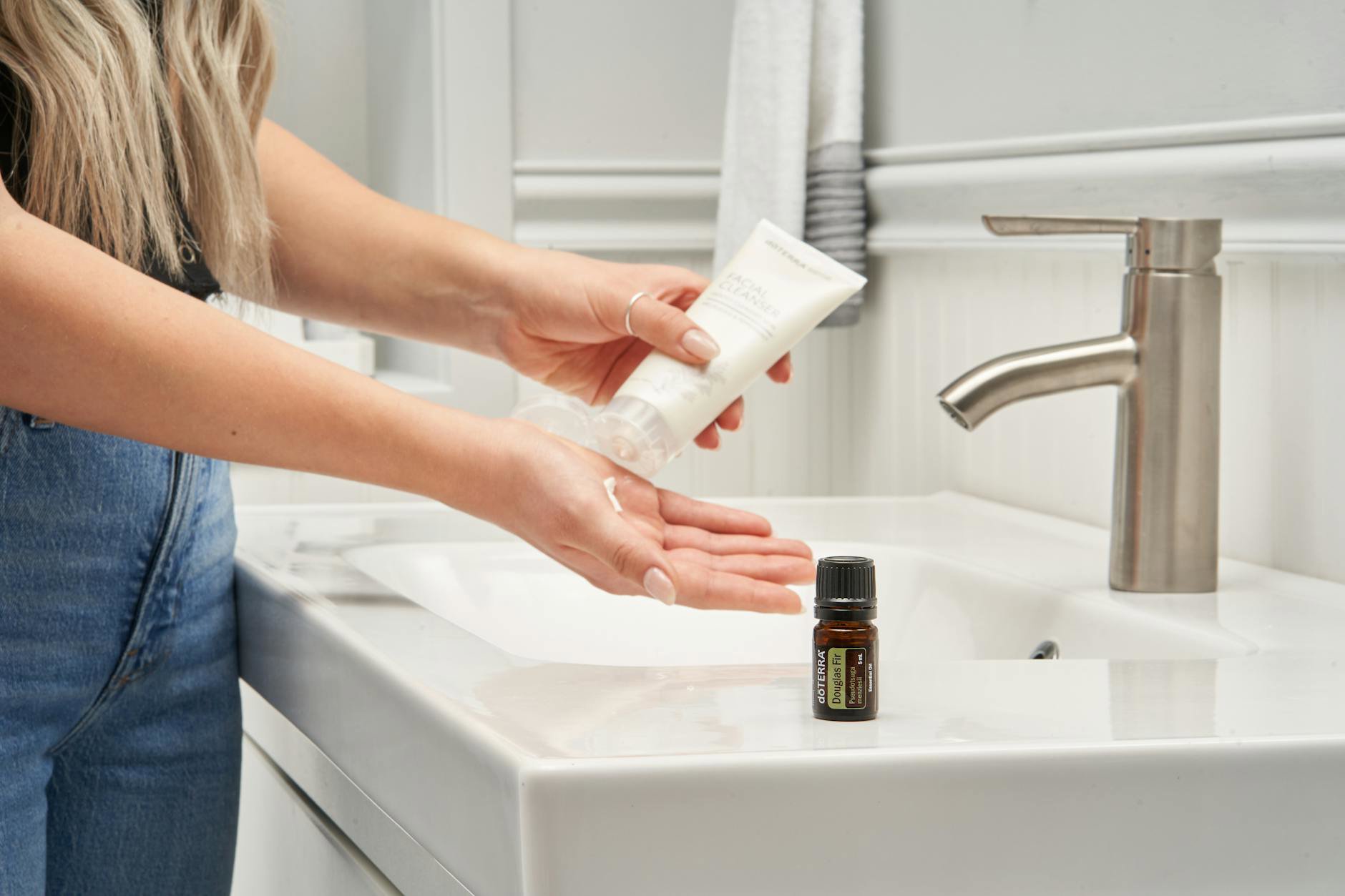 woman doing skincare routine at bathroom sink