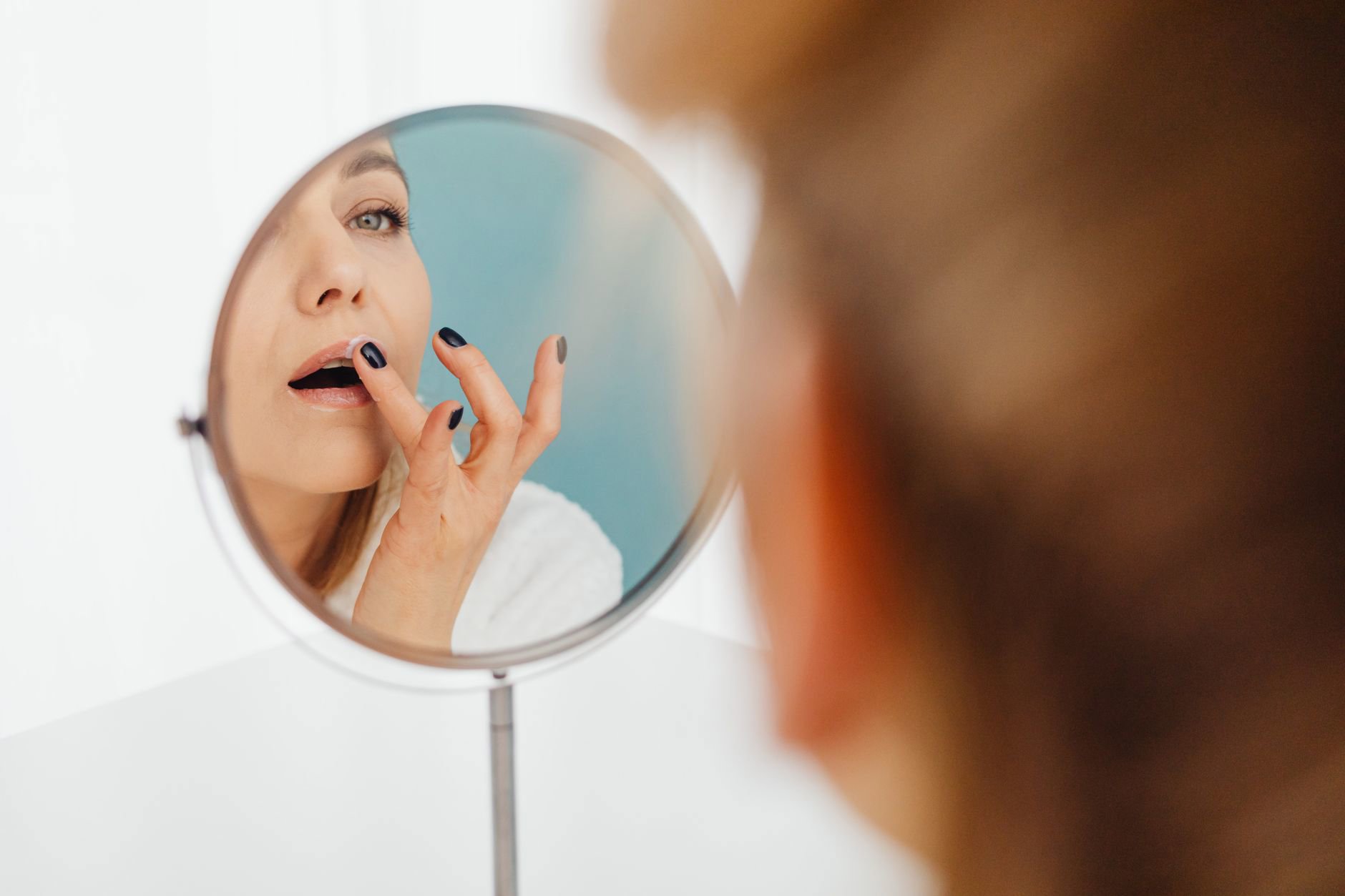 woman applying lip stain mirror