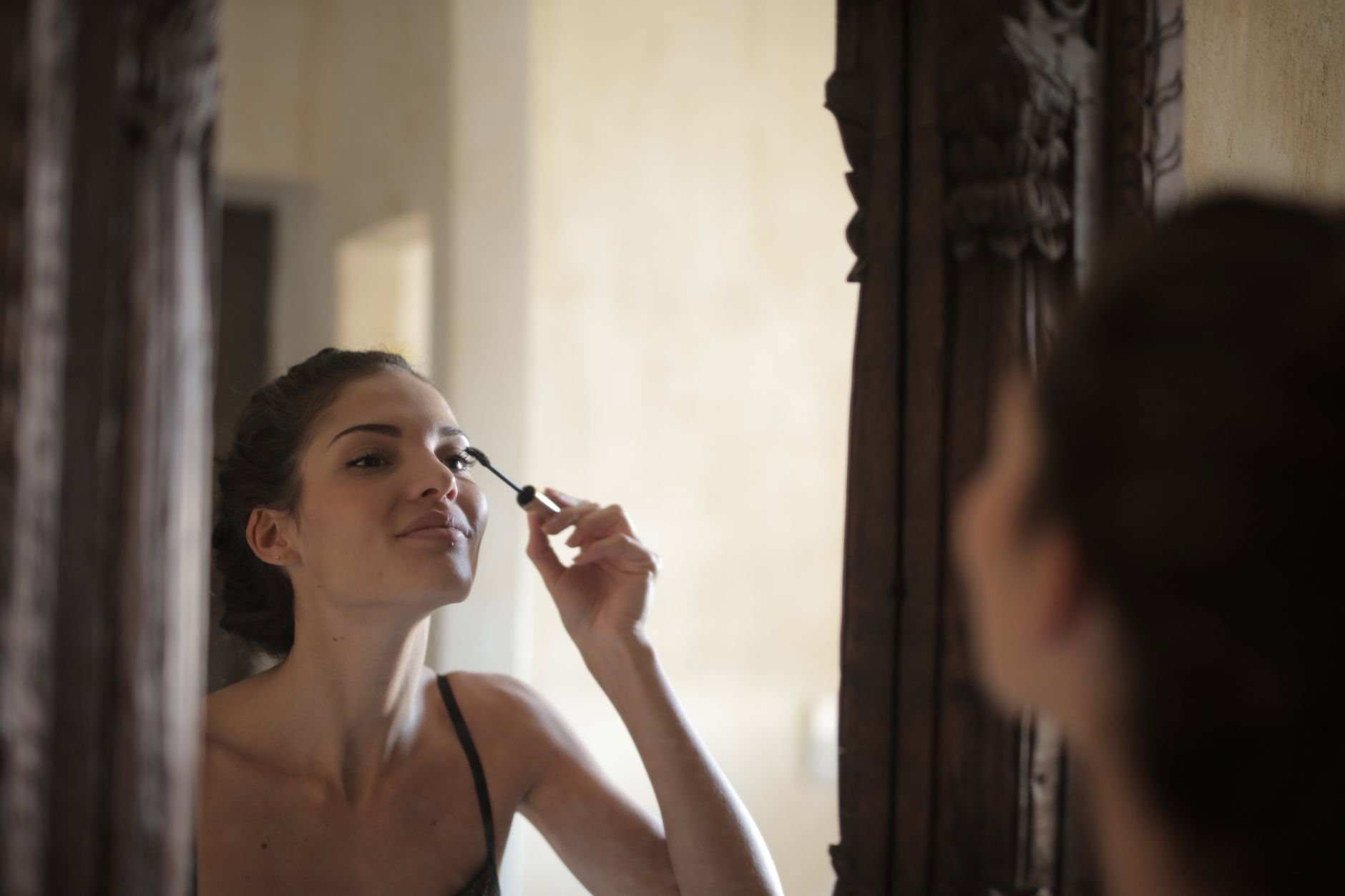 woman applying liquid eyeliner mirror