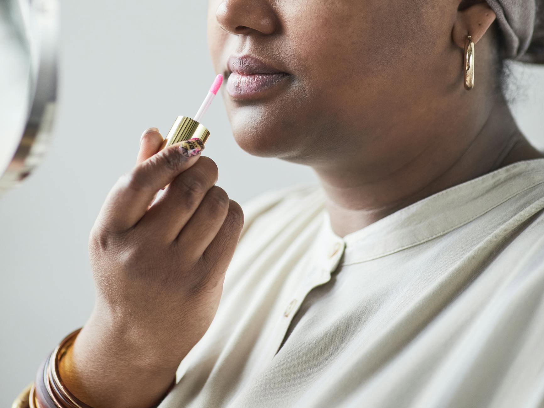 woman applying lip gloss close up