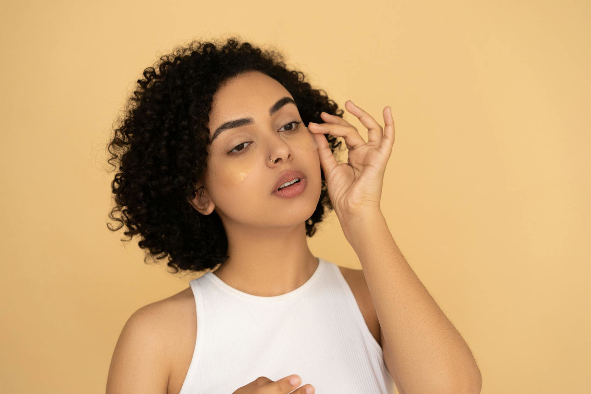 woman applying concealer under eyes natural light