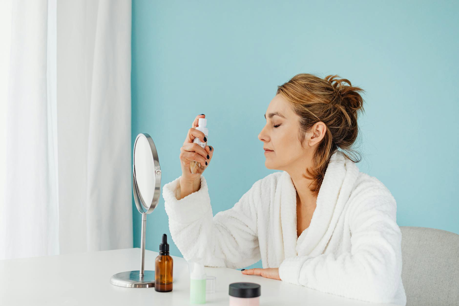 woman applying setting spray close up