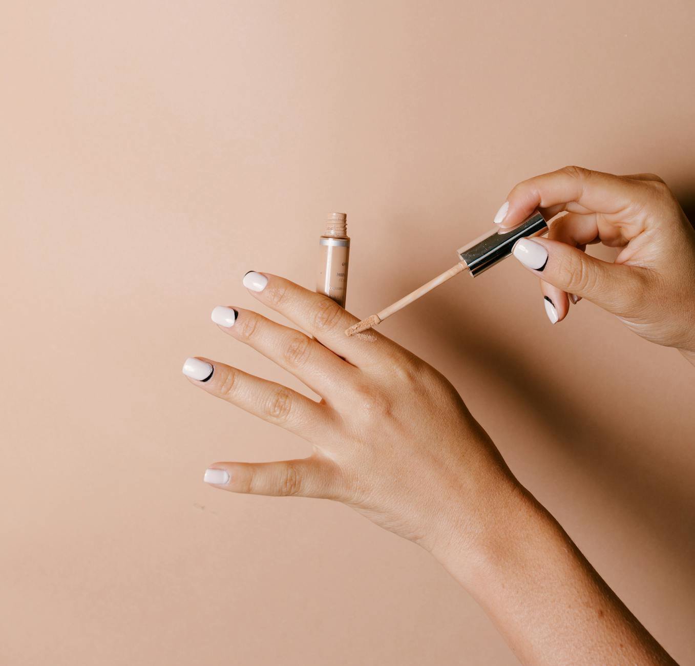 woman applying concealer with fingertip close up
