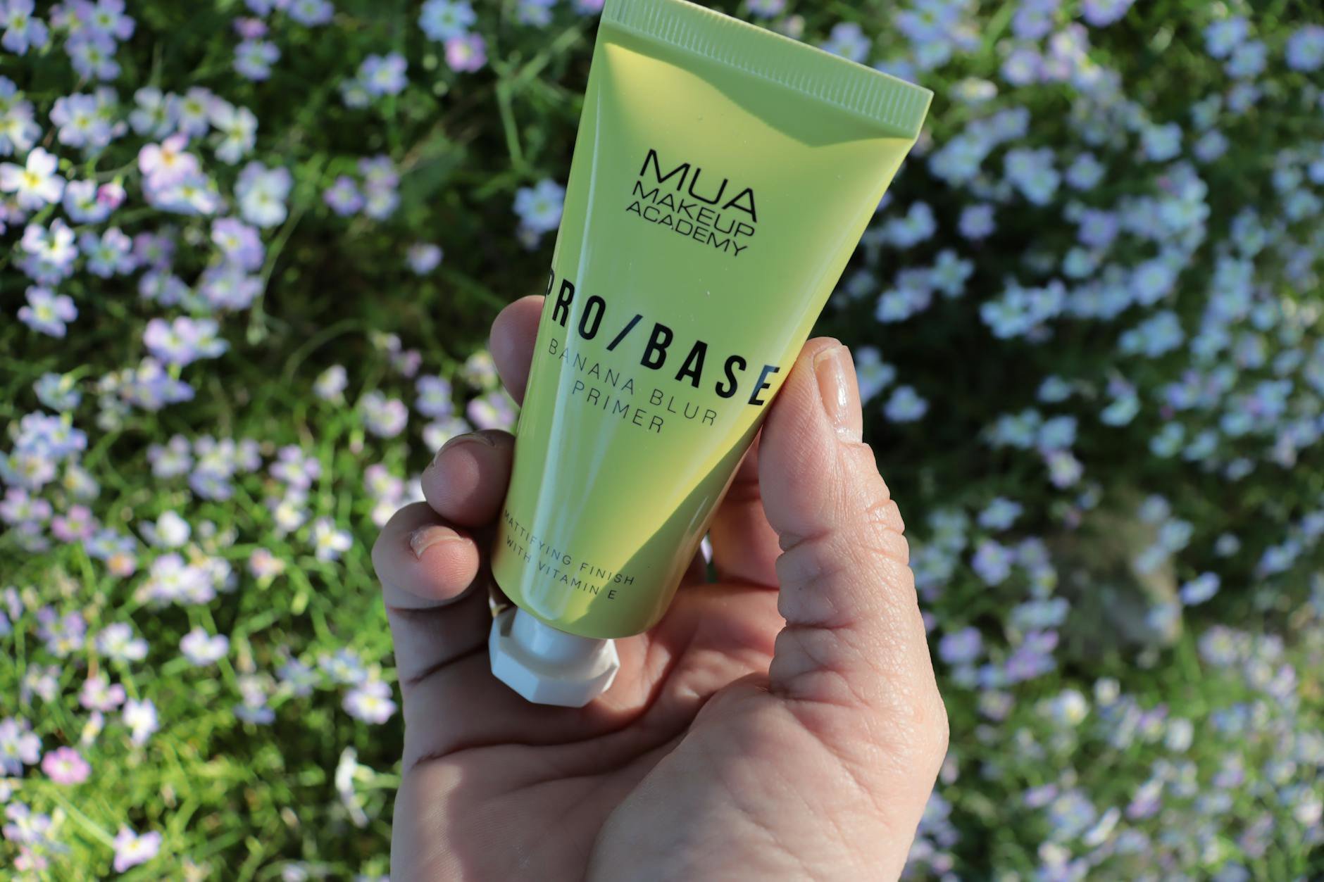 woman holding makeup primer tube checking expiry symbol