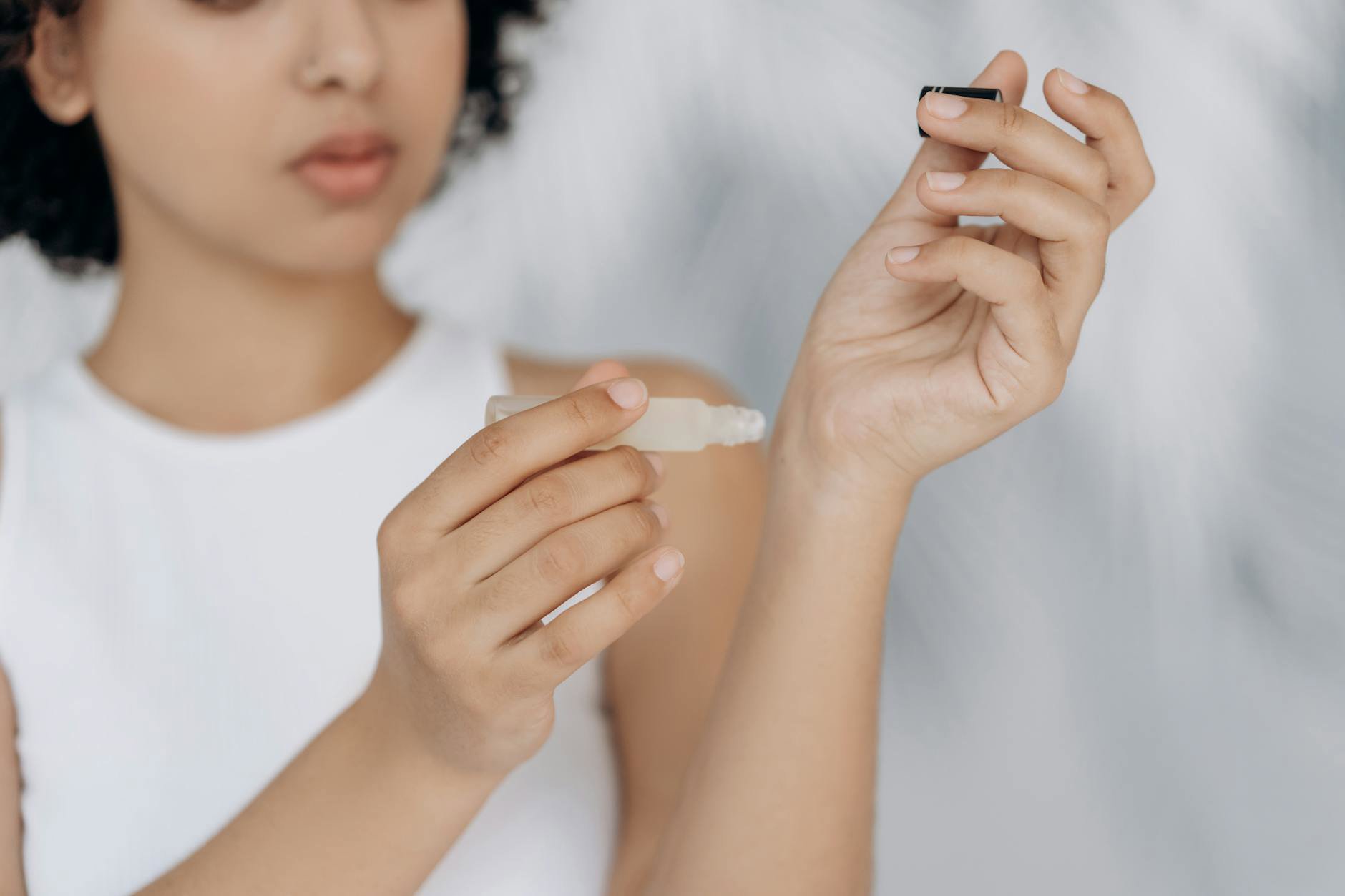 woman applying perfume on wrist close up