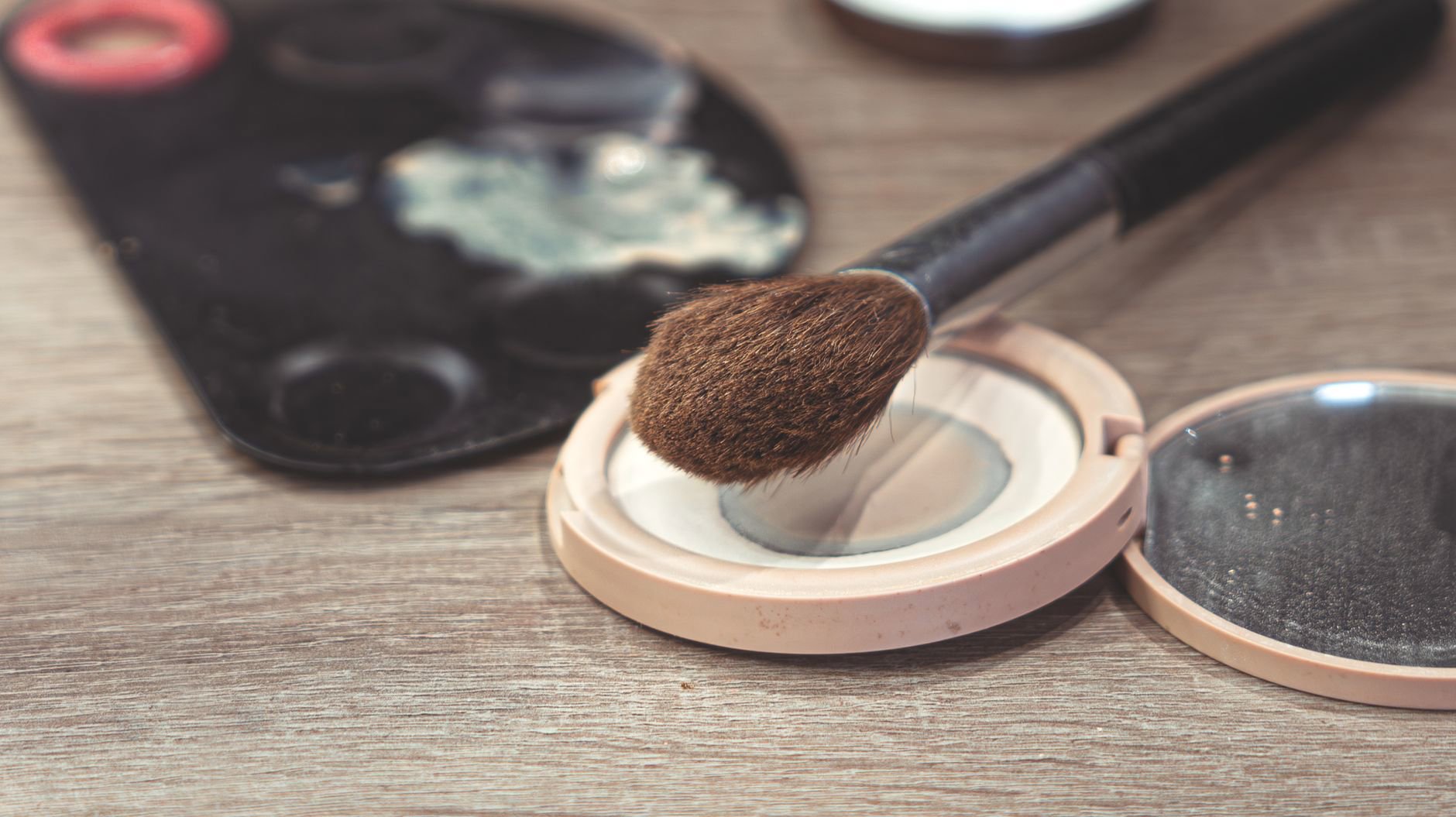 pressed powder compact and fluffy brush close up