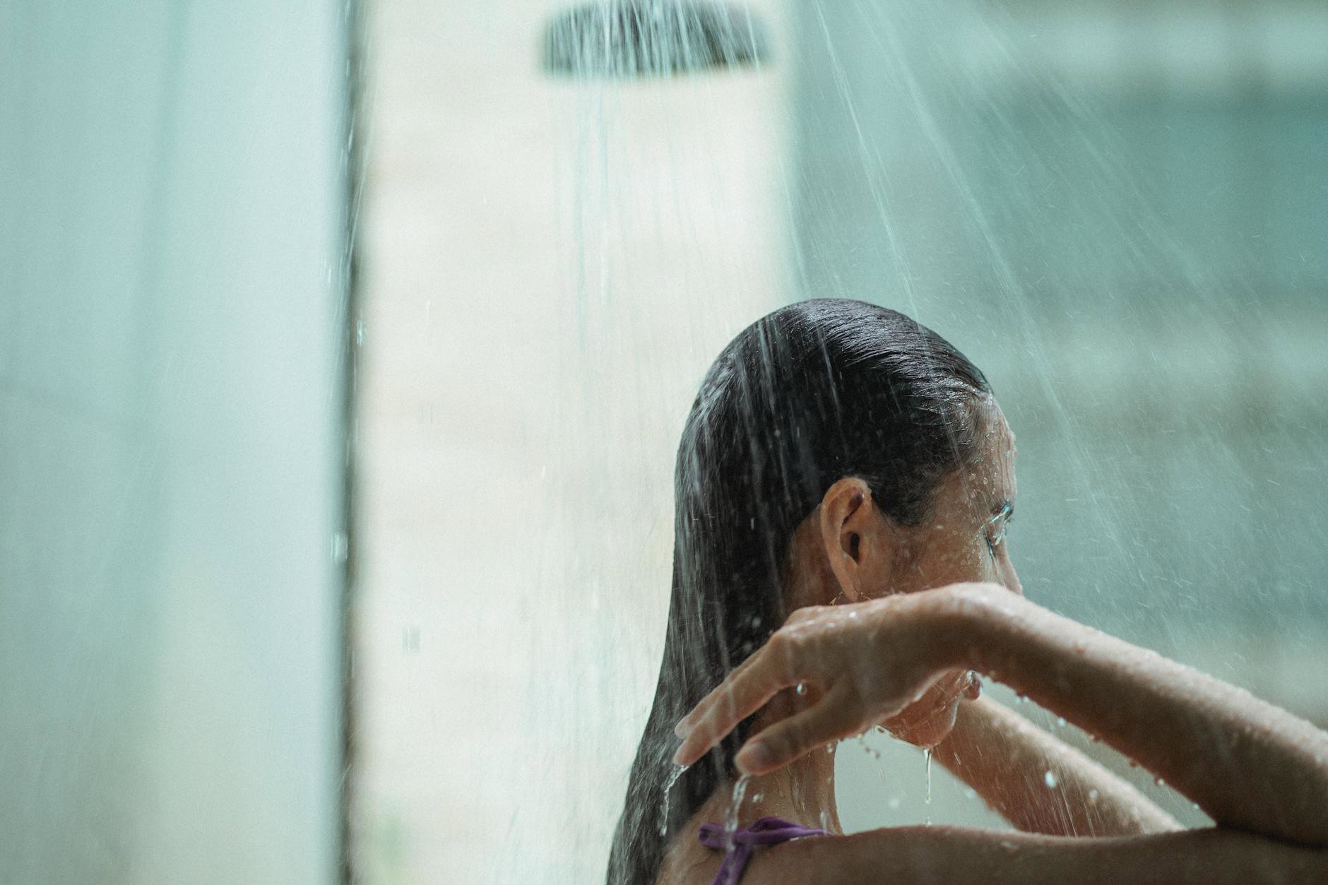 woman applying conditioner to wet hair shower