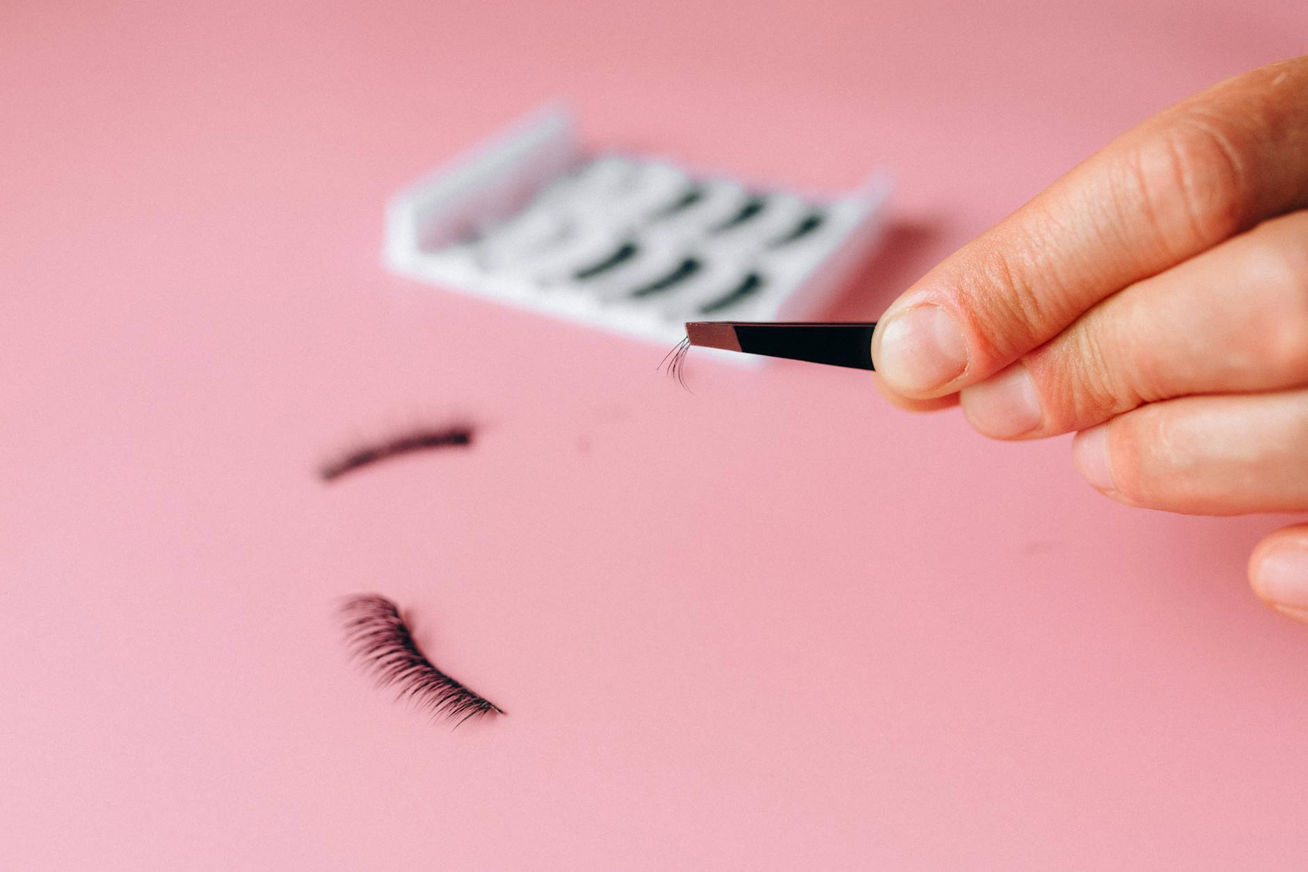 cleaning false lashes on tissue with tweezers