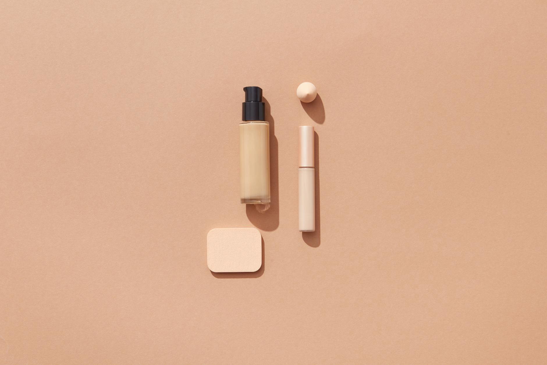 liquid foundation bottles flatlay neutral background