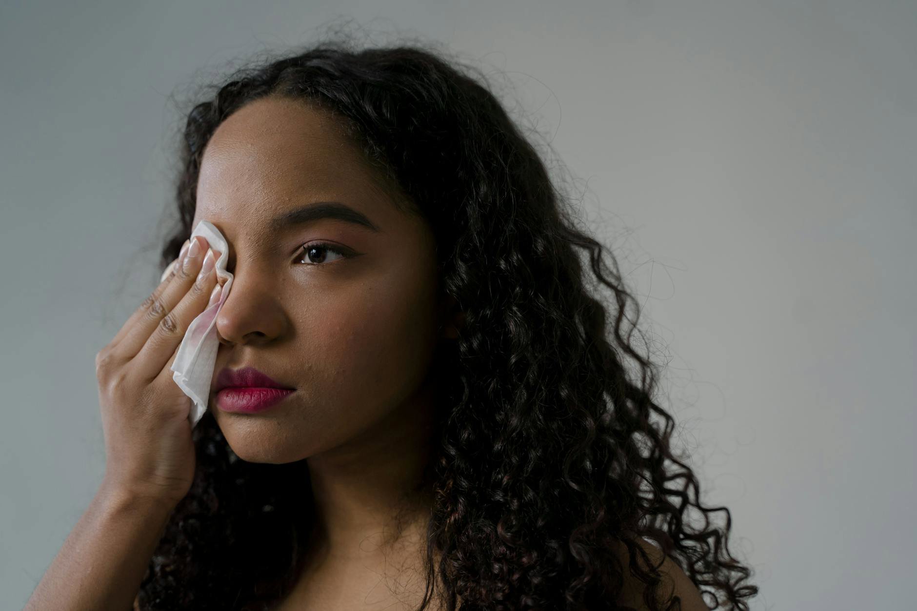 woman blotting lipstick with tissue