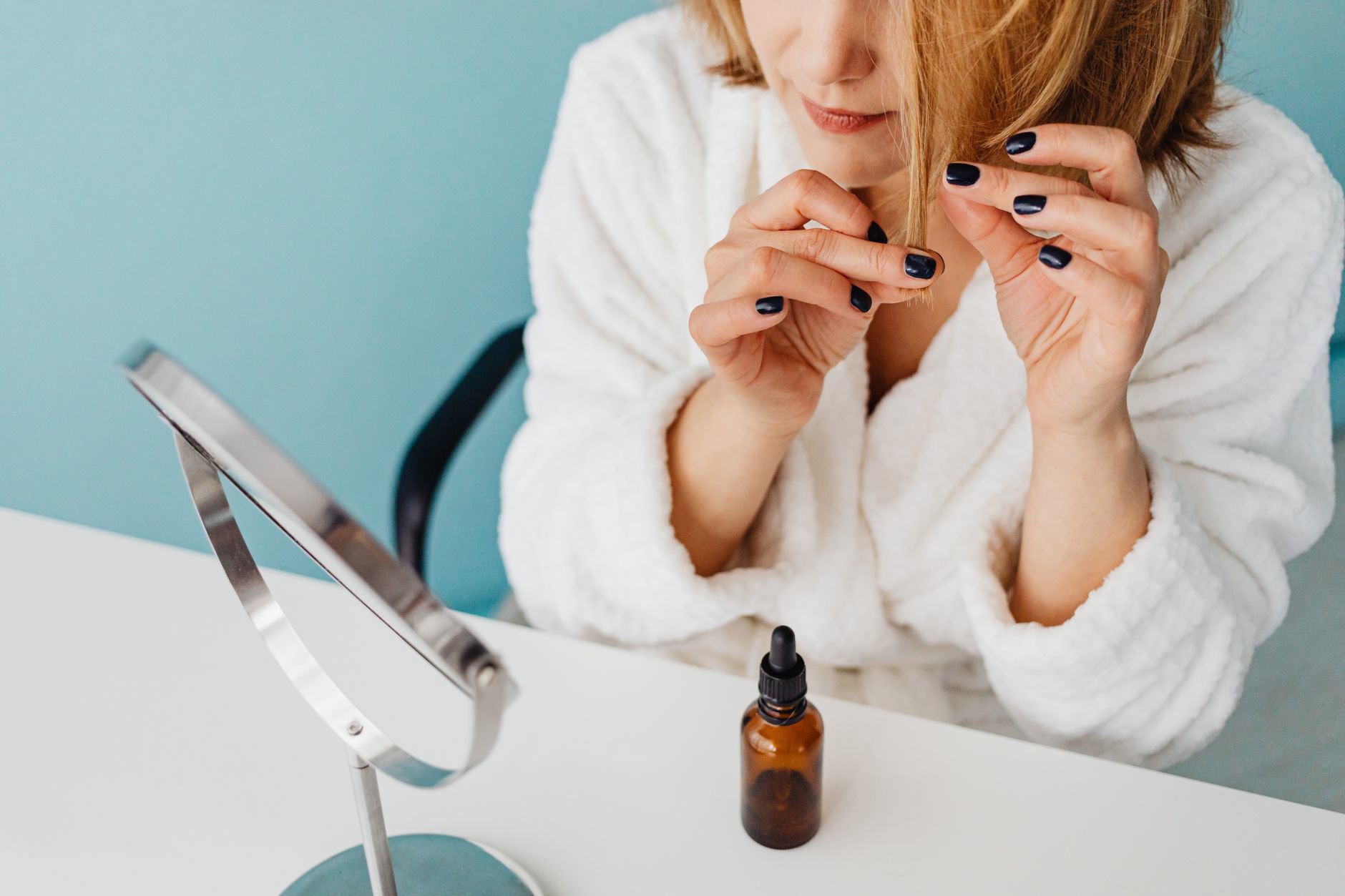 woman applying hair serum to ends