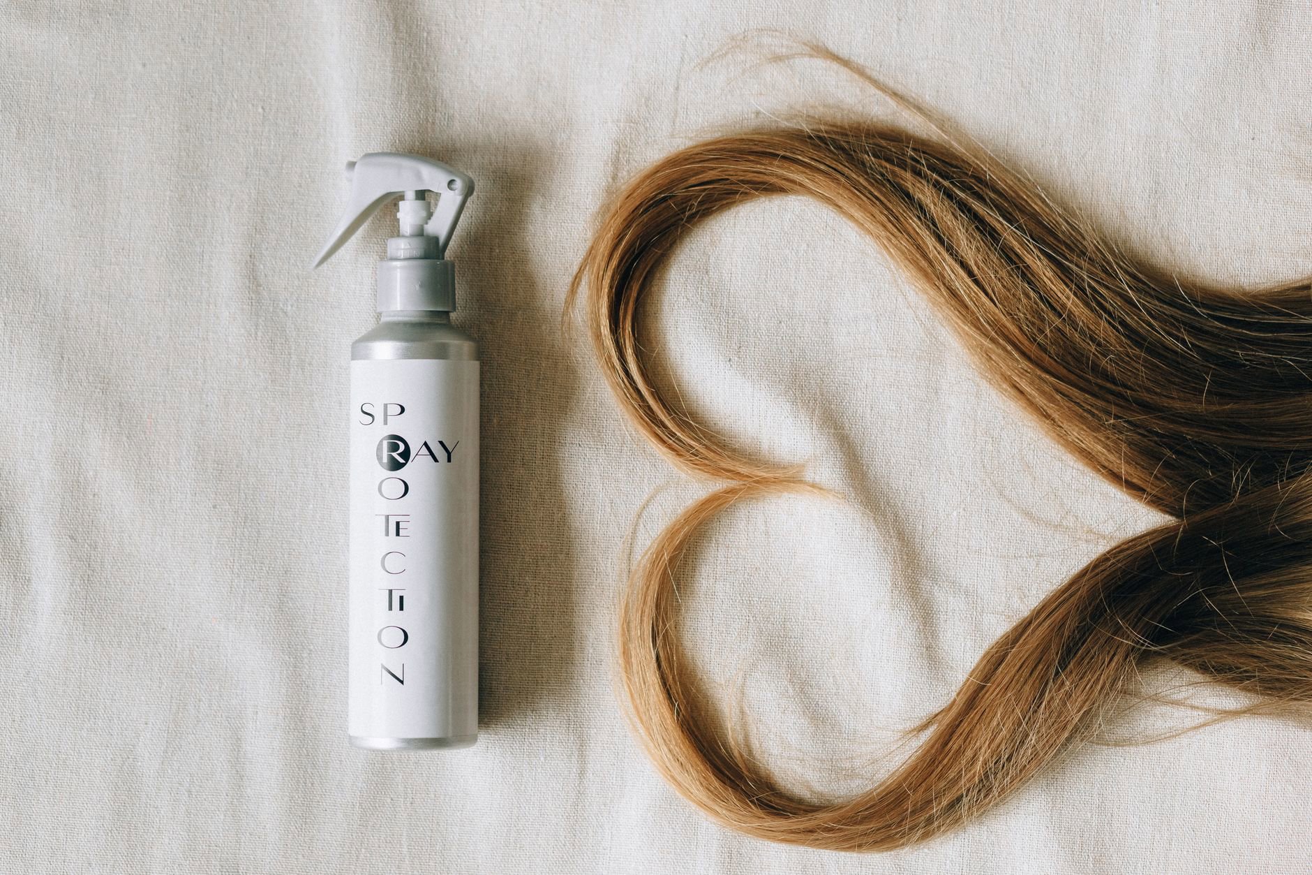 flatlay leave in conditioner creams and sprays on white background