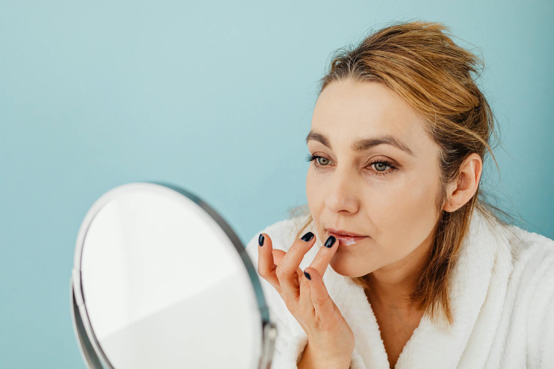 woman applying lip mask mirror