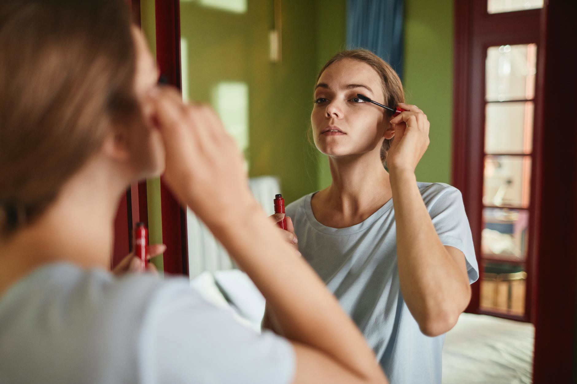 woman applying mascara close up defined lashes