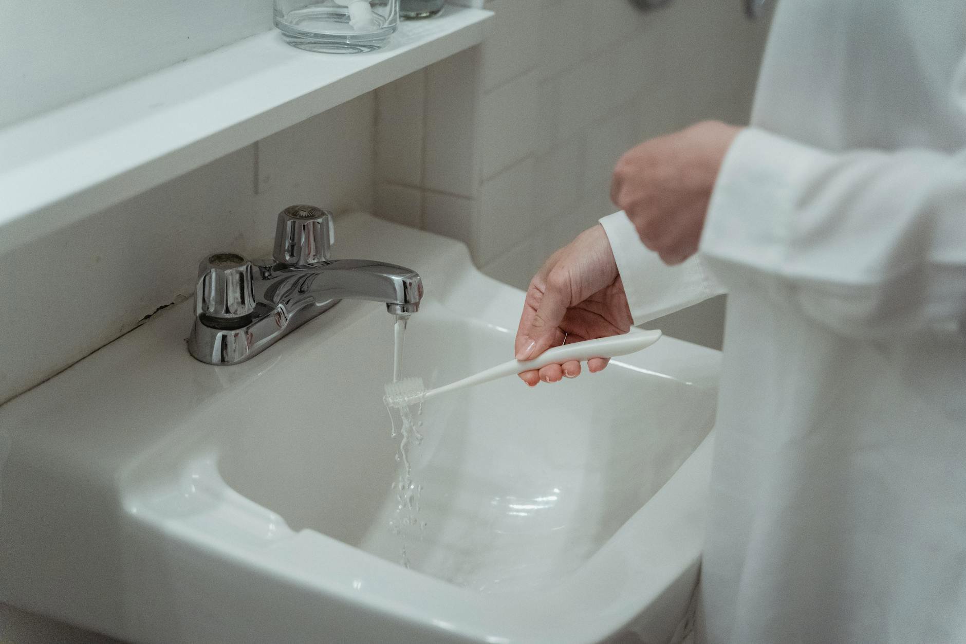 woman rinsing face lukewarm water sink