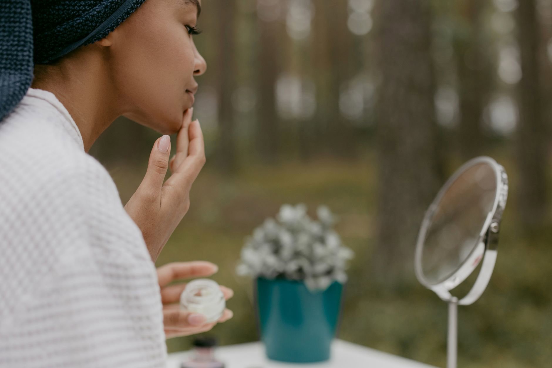 woman applying gel moisturizer mirror