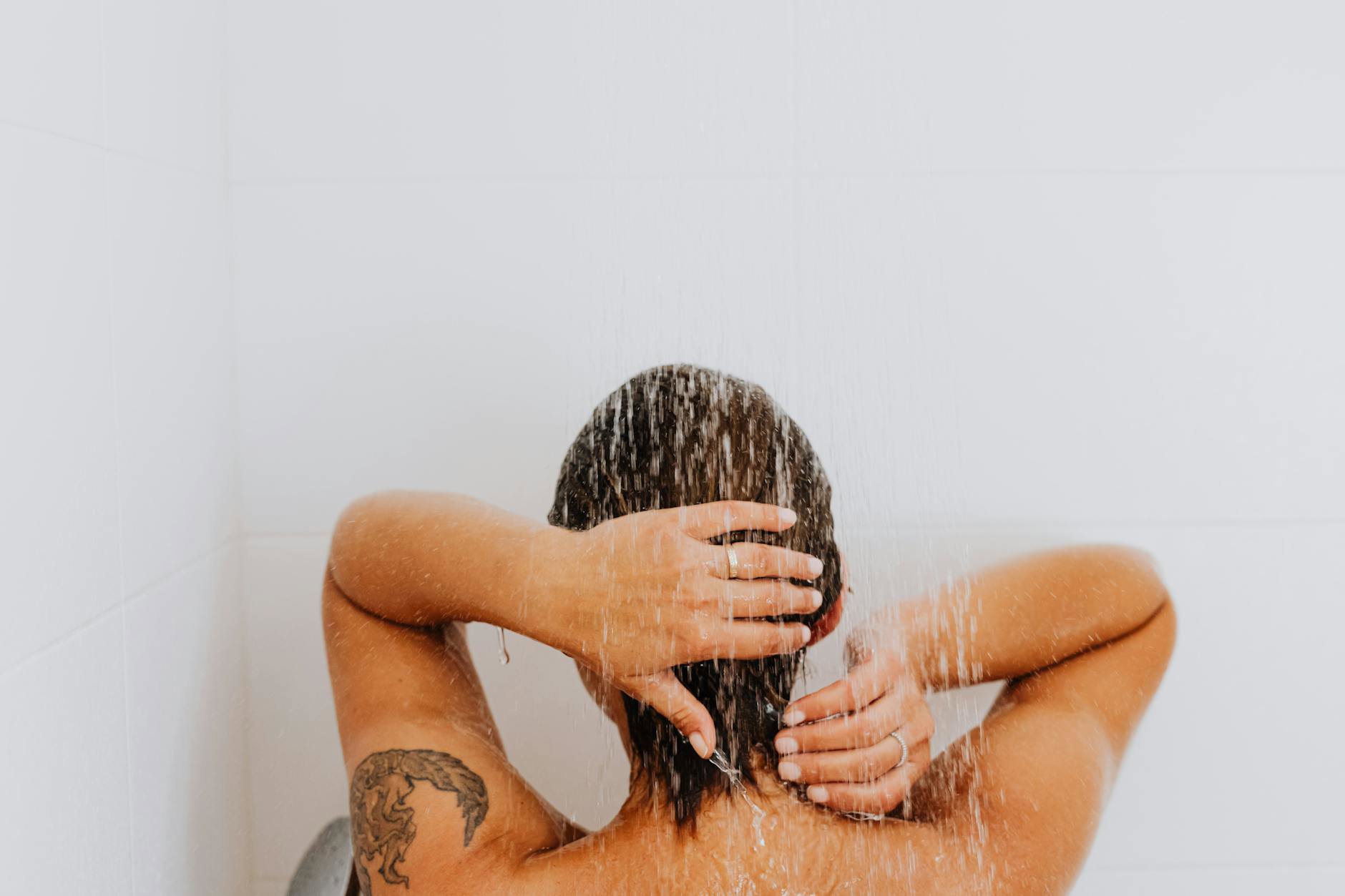 woman massaging scalp in shower