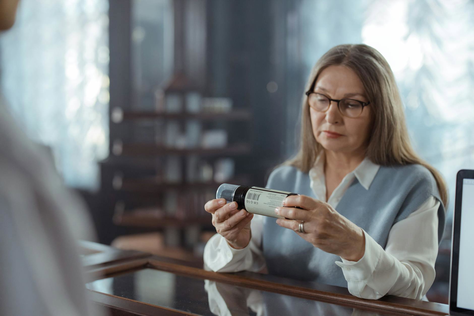 woman reading skincare ingredients label in drugstore