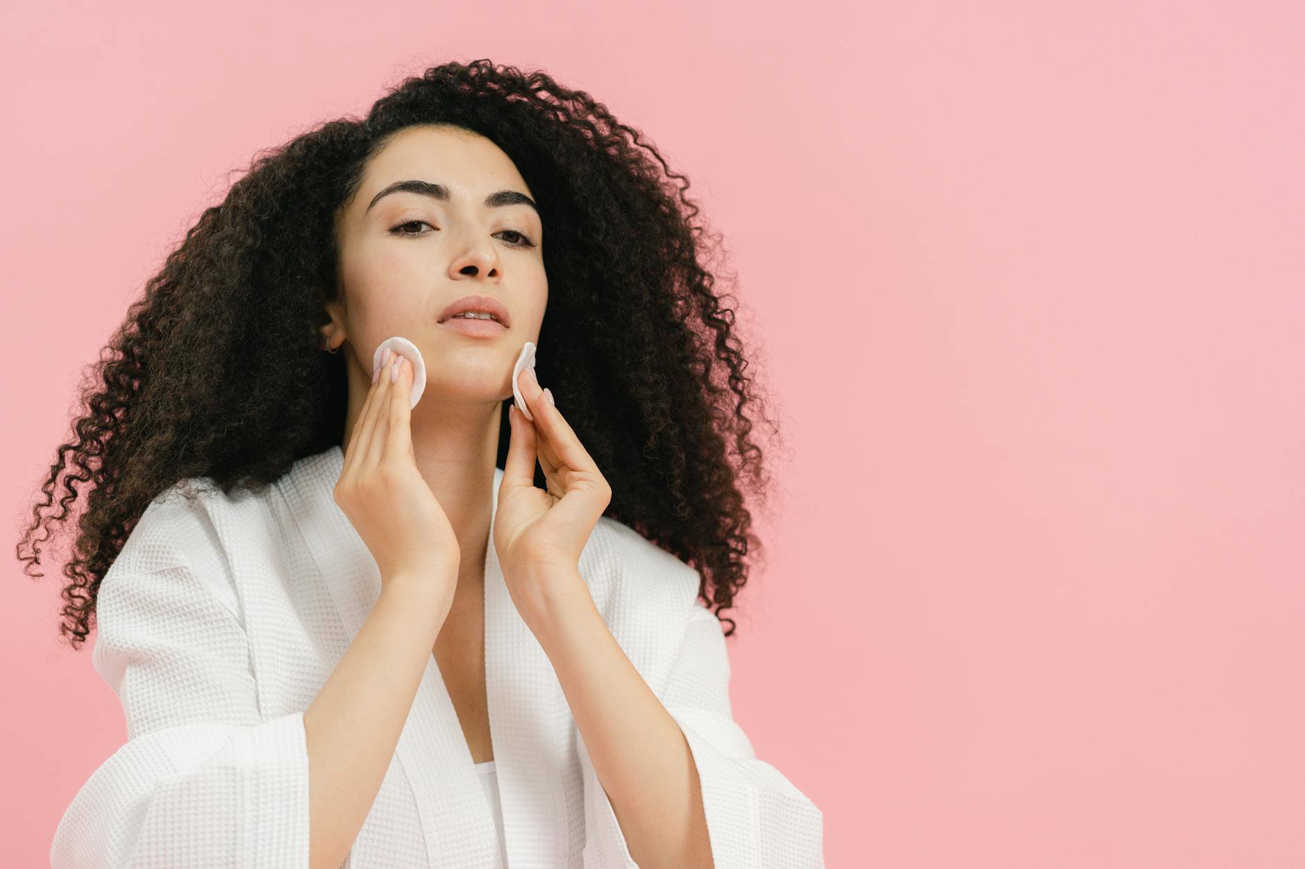 woman removing makeup with cleansing milk cotton pad
