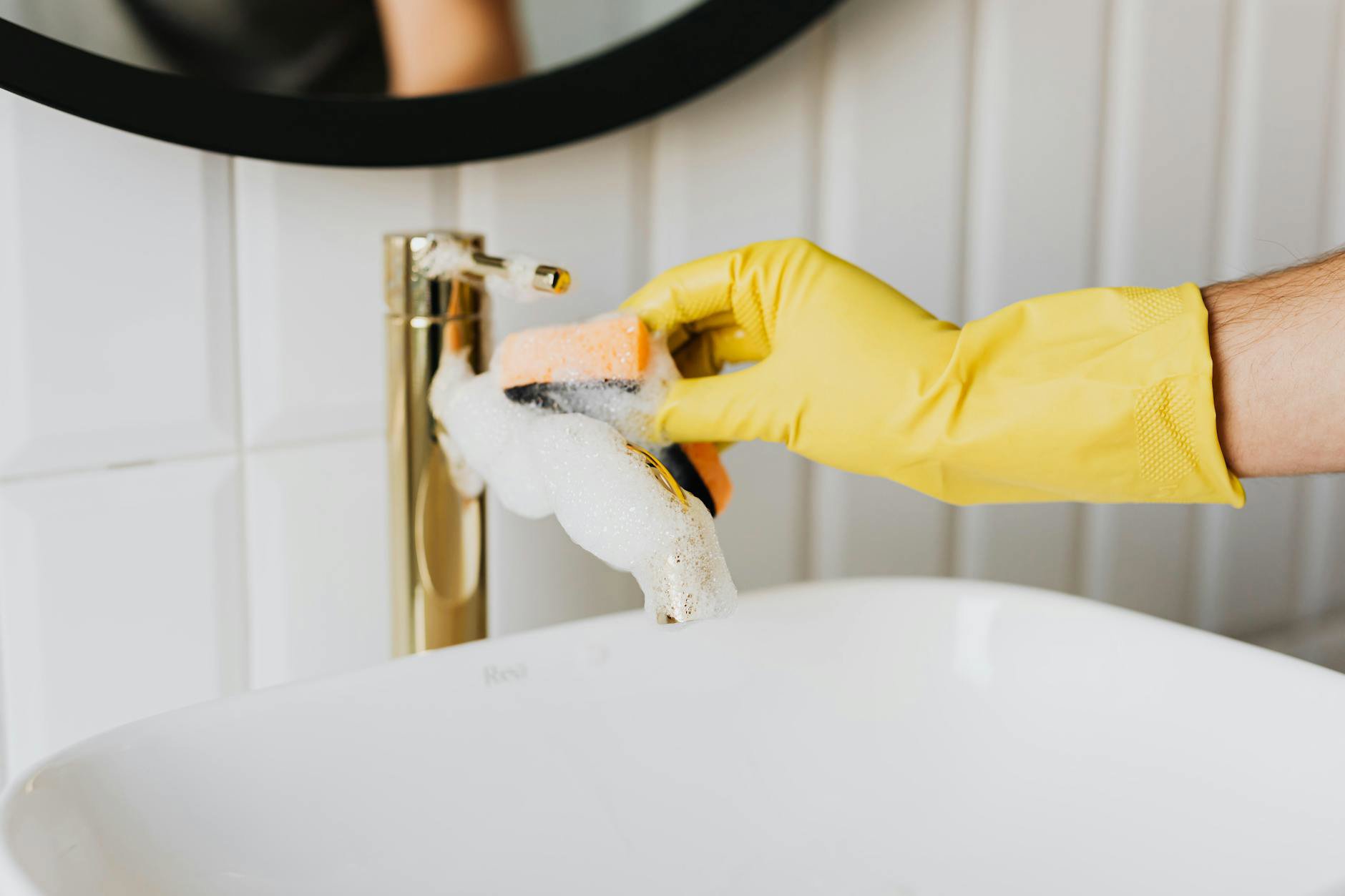 woman cleaning makeup sponge in bathroom