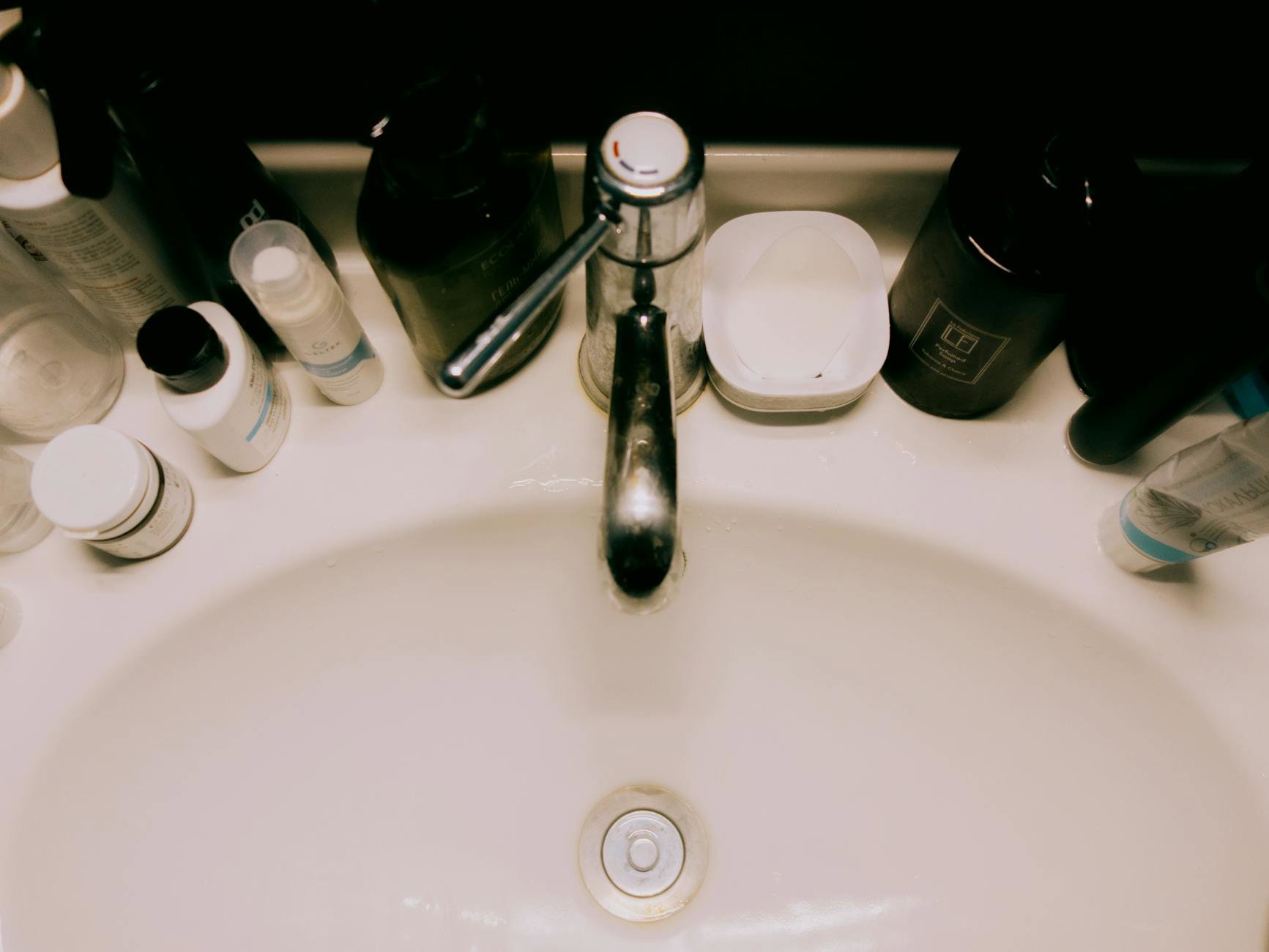 cleanser bottle on sink with towel flatlay