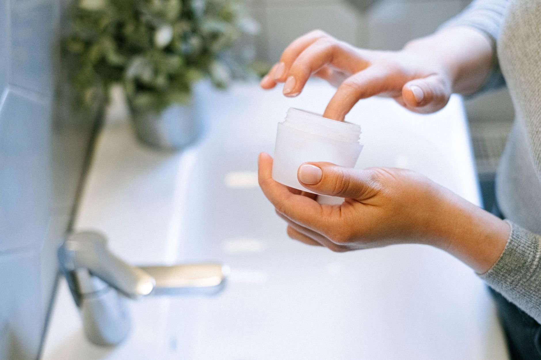 woman applying milky toner with hands face close up