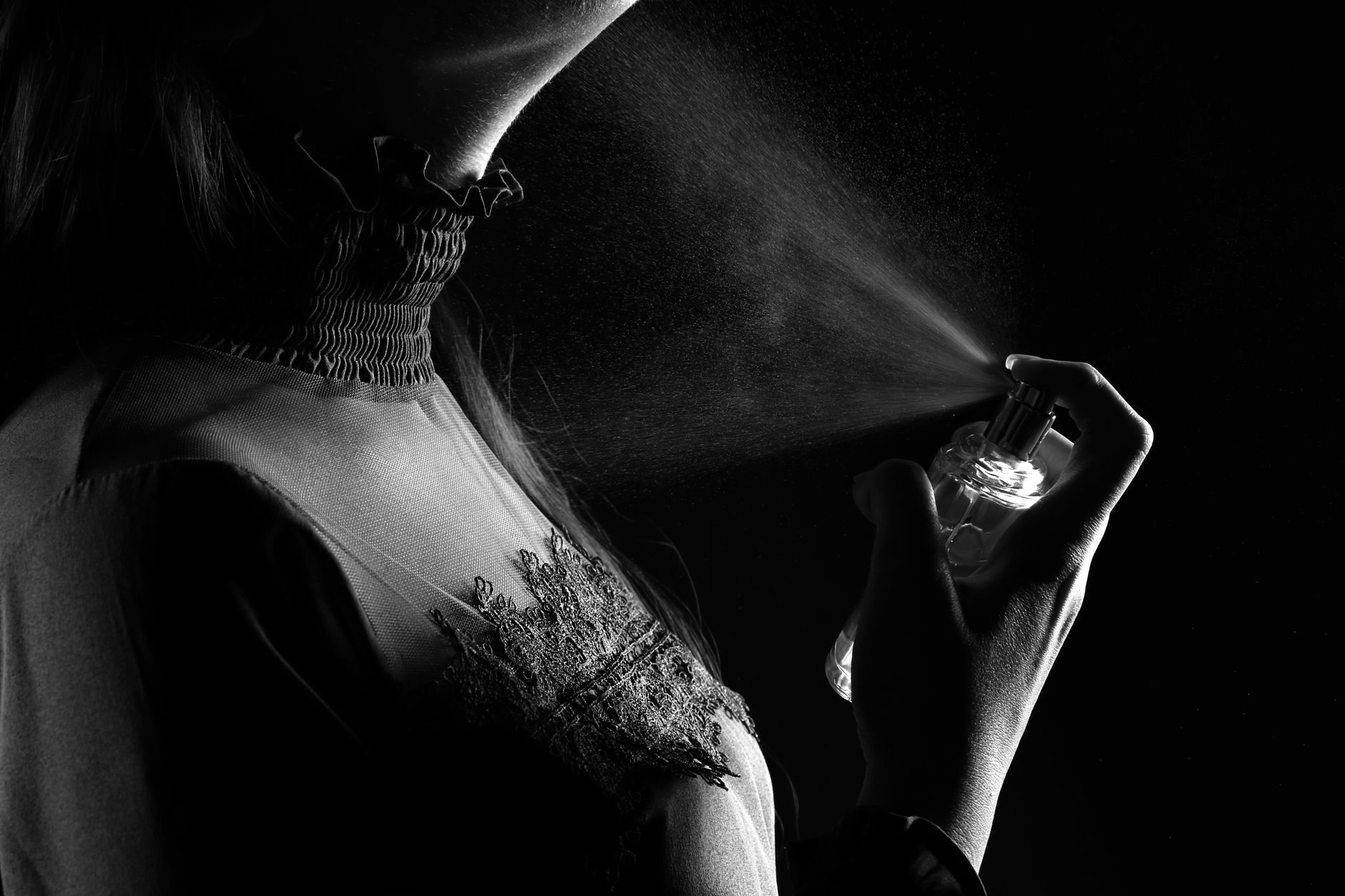 woman spraying perfume on wrist close up