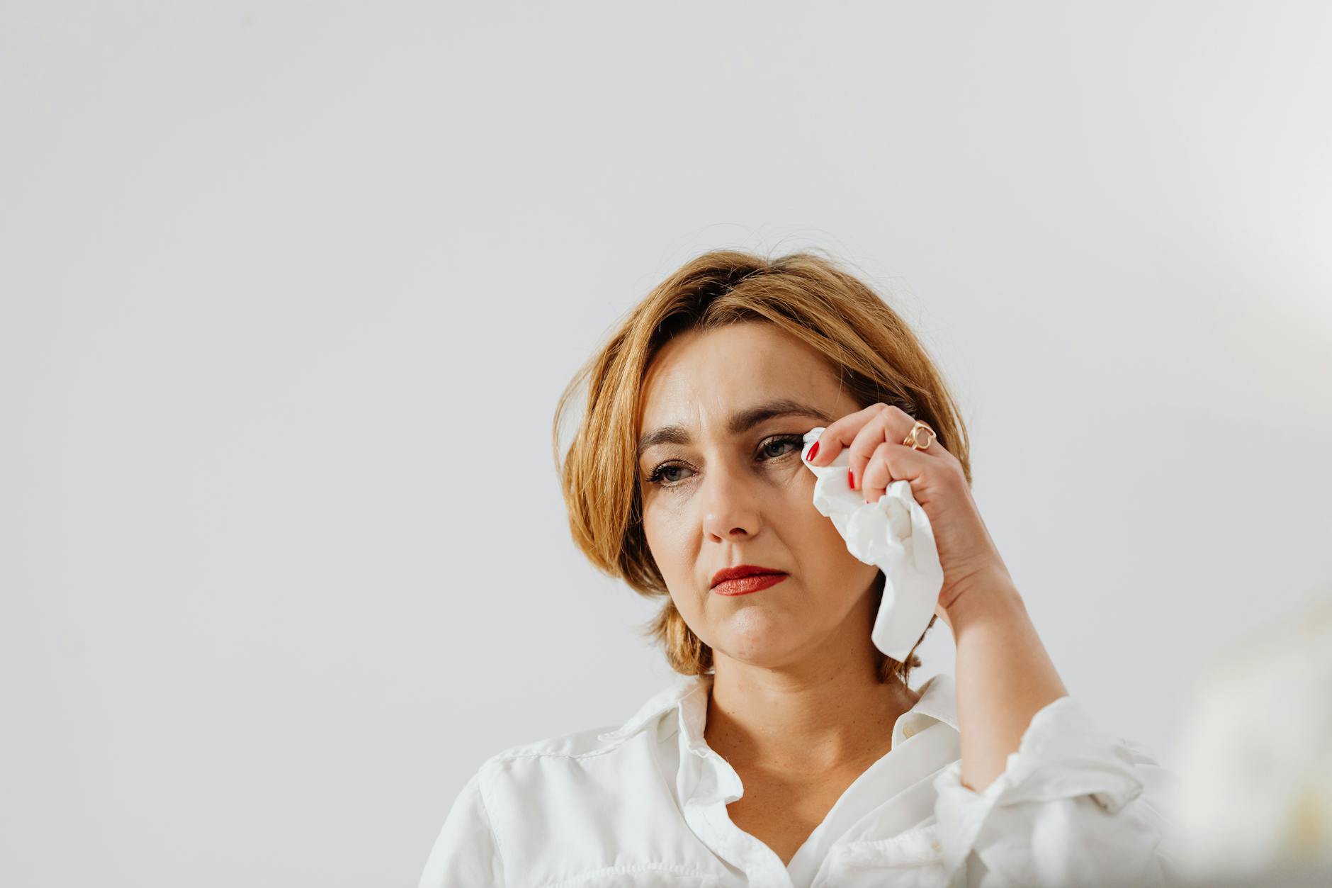 woman blotting lips with tissue mirror