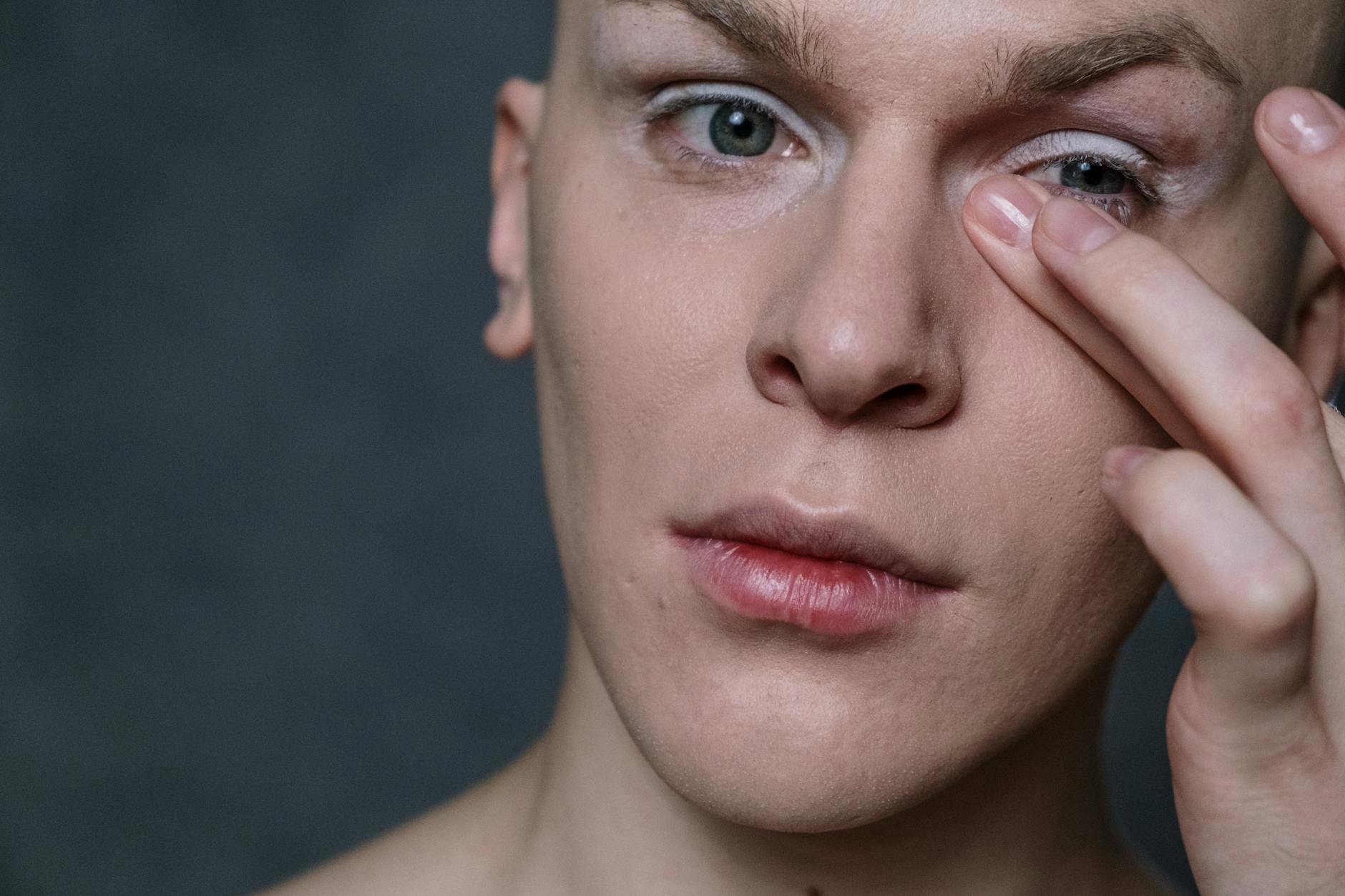 woman applying concealer under eye close up
