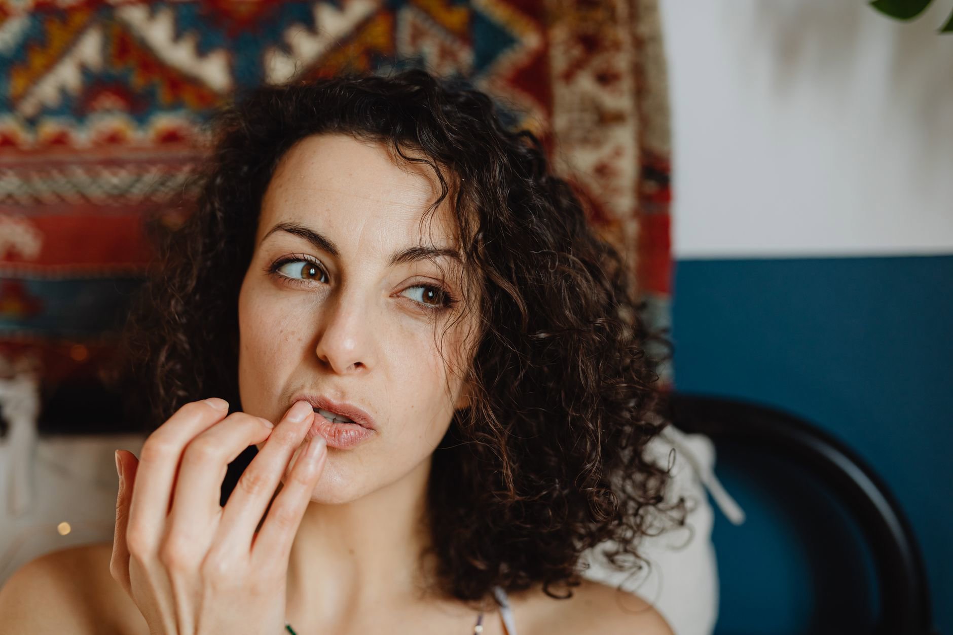 woman with curly hair applying hair product