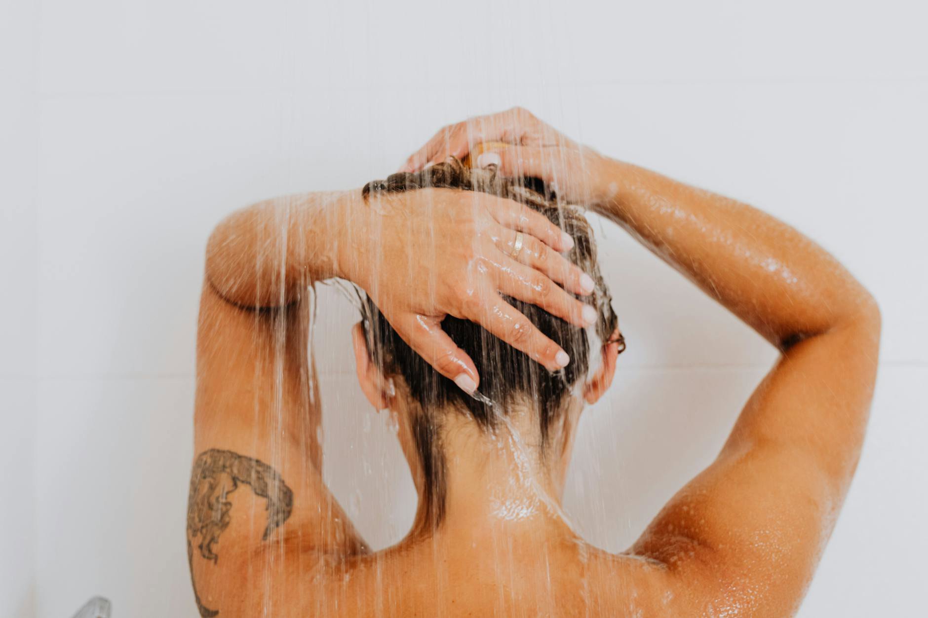 woman washing hair shower morning light