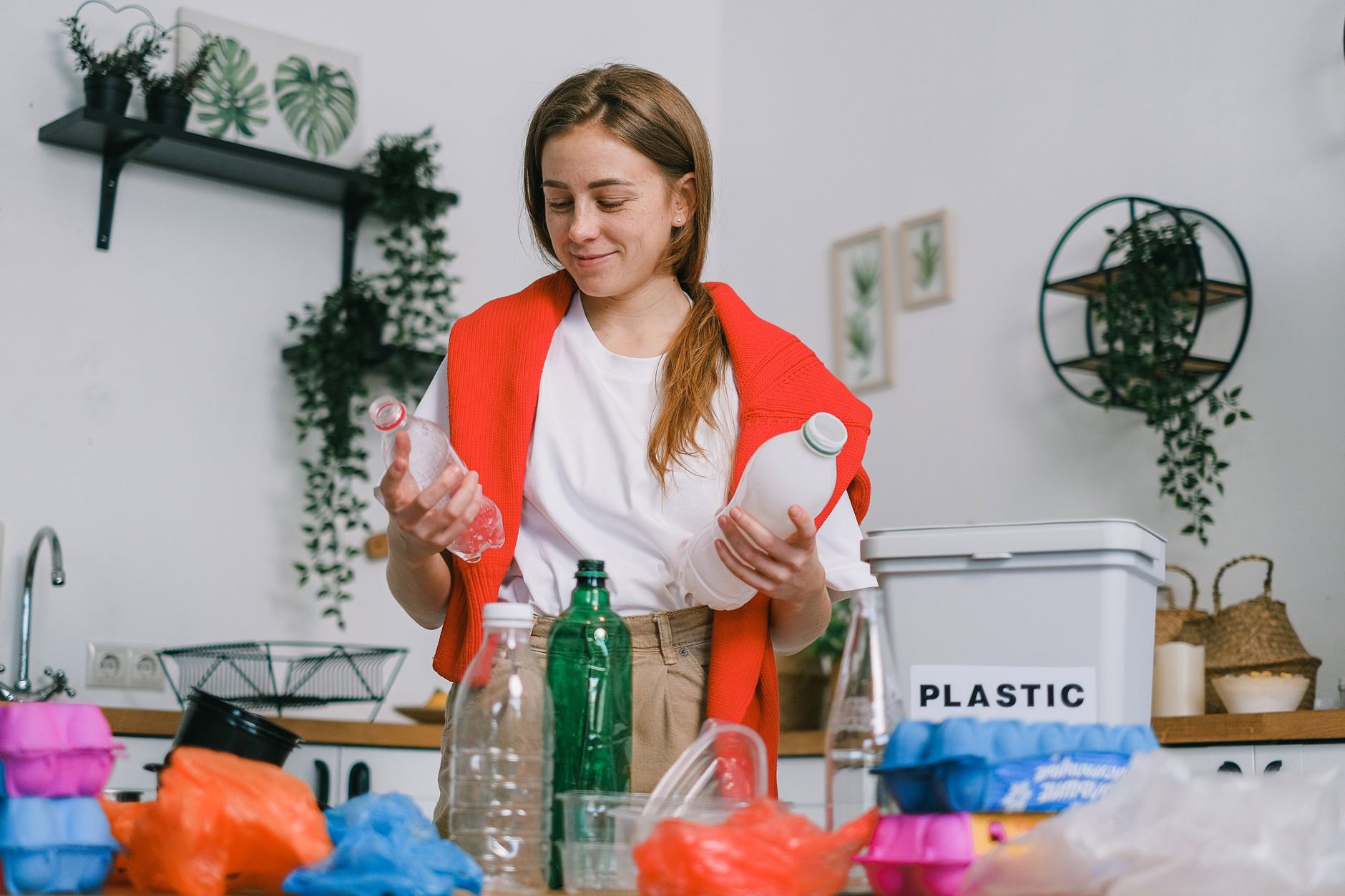 woman sorting empty skincare bottles for recycling