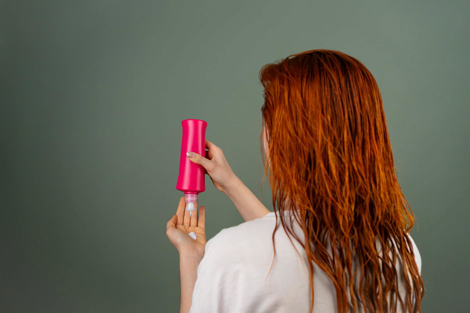 woman applying hair conditioner in shower