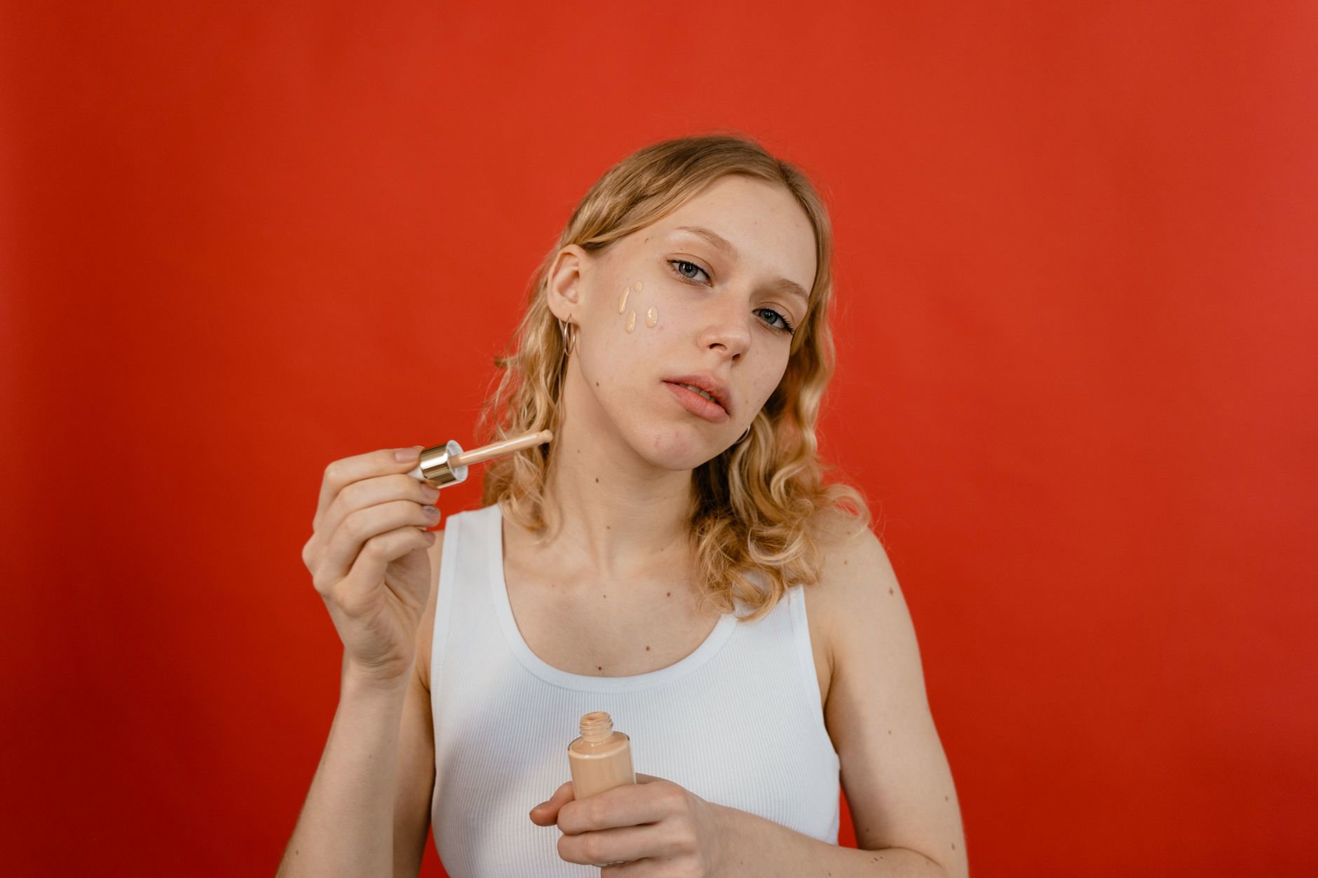 woman applying tinted moisturizer natural light