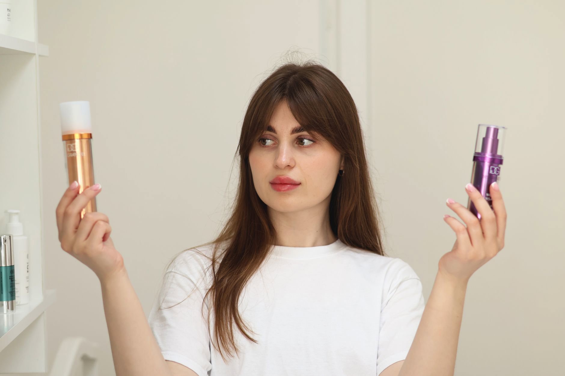woman comparing skincare bottles at vanity