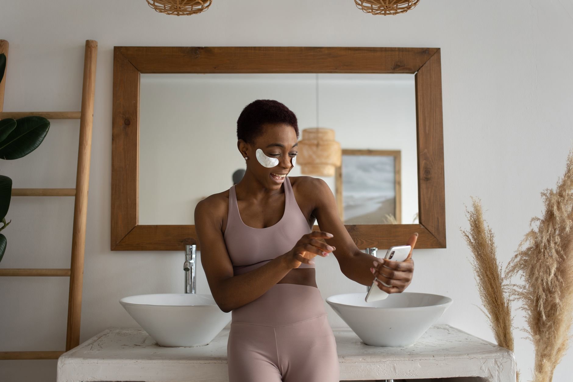 woman comparing skincare prices on phone in bathroom mirror