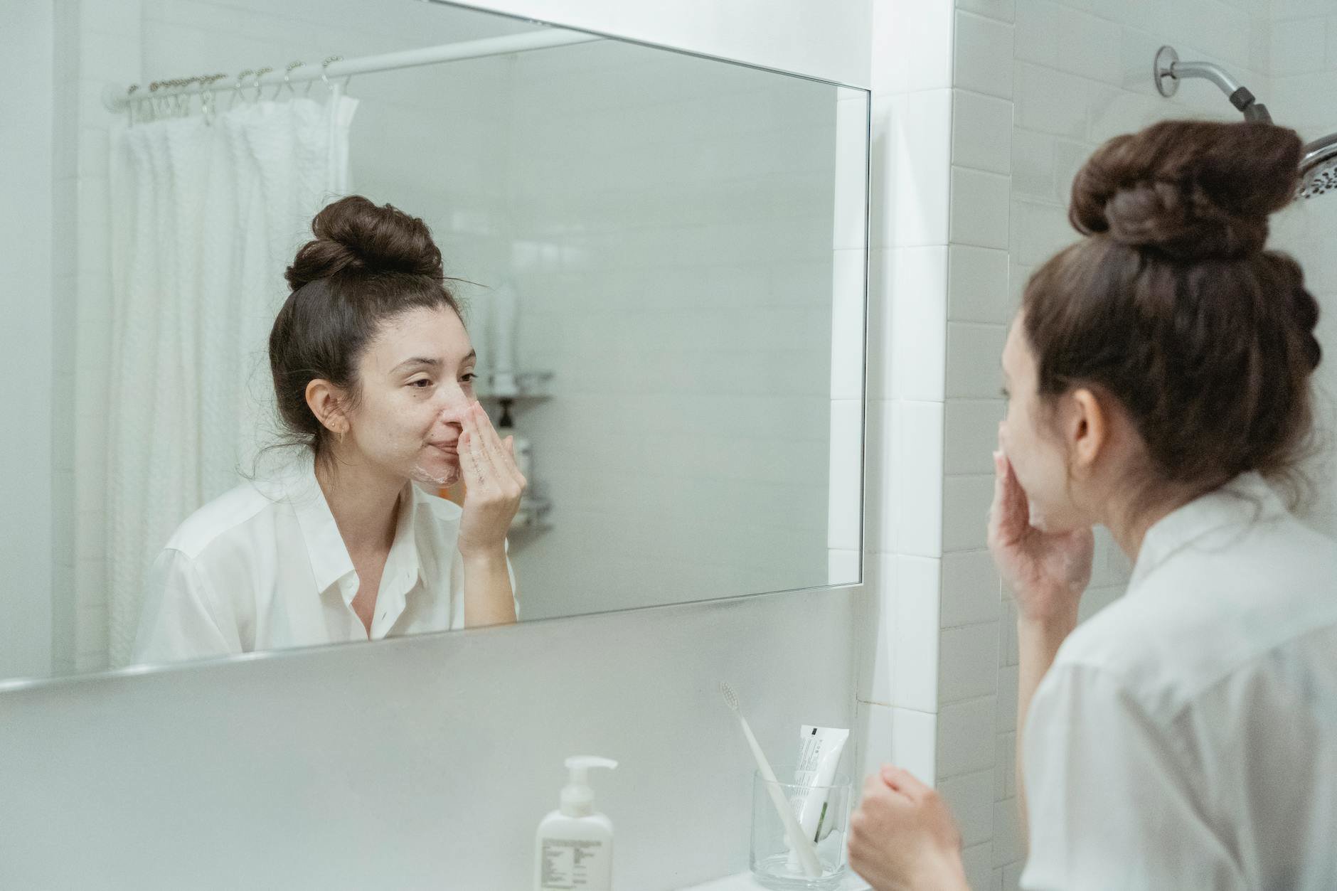 woman scrolling tiktok skincare bathroom mirror