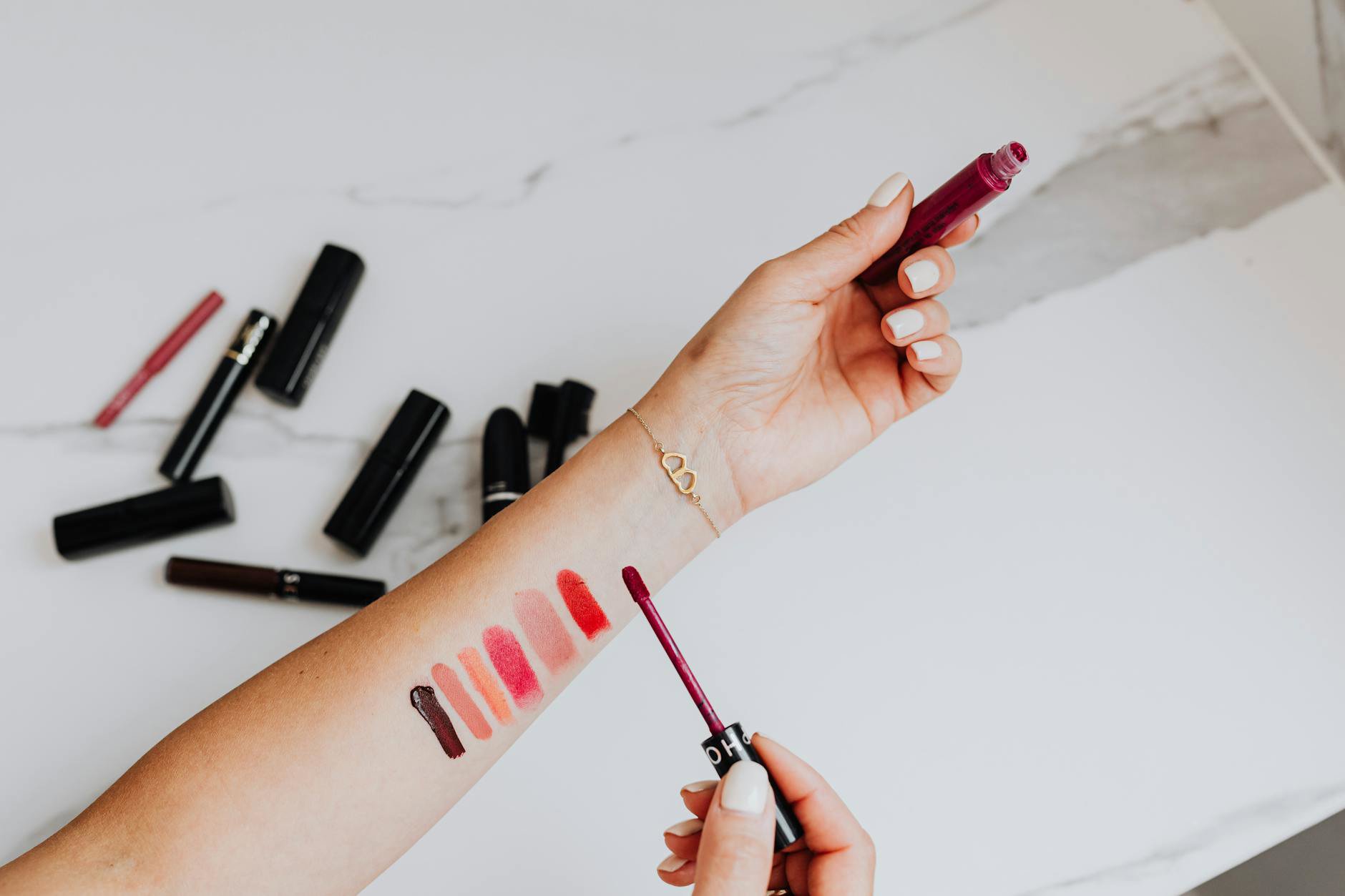 vegan lipstick swatches on hand woman