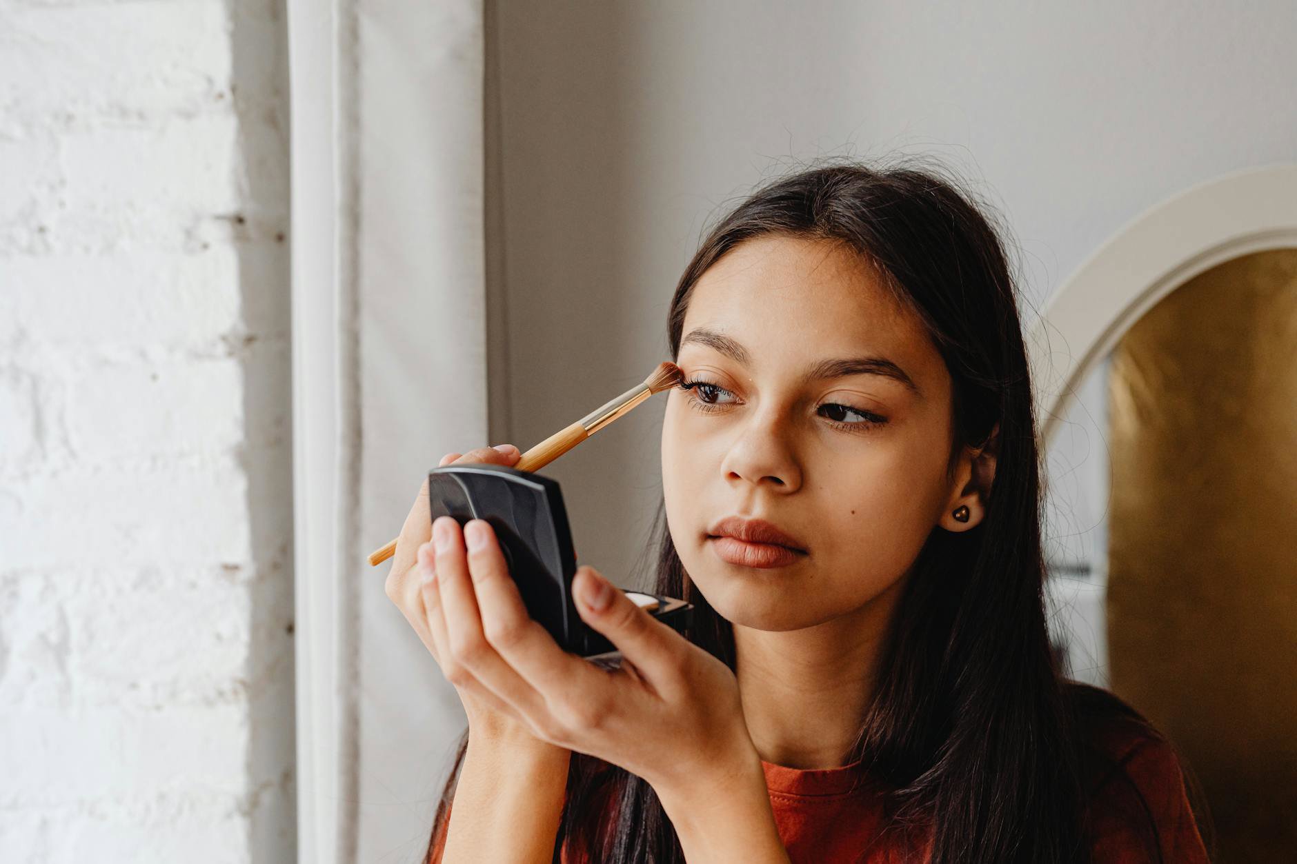 woman applying pastel eyeshadow mirror